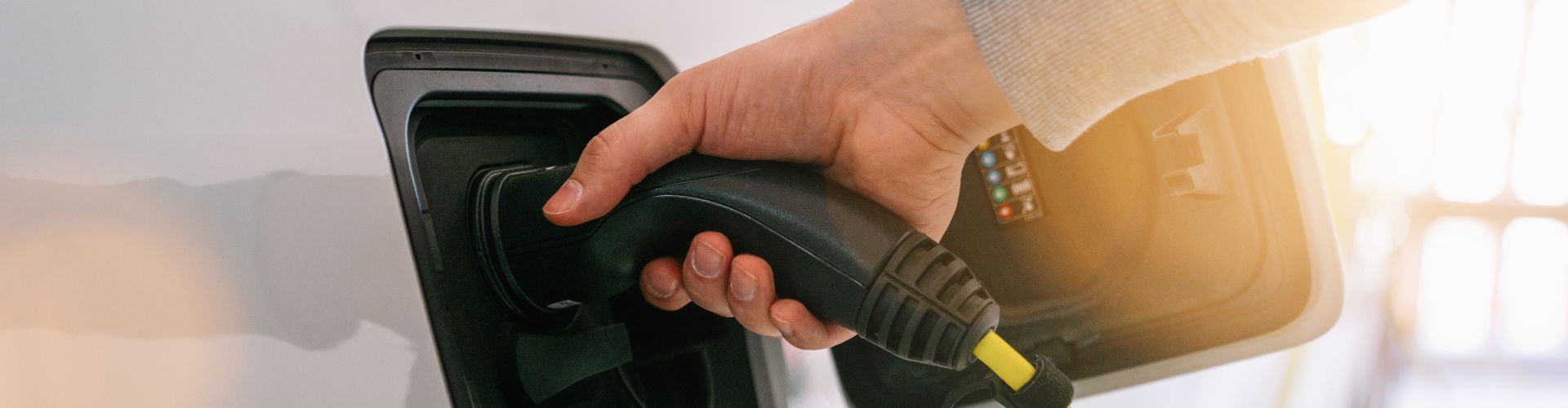 Hand Holding Electric Car Charger. Power Supply Electric Car Charging