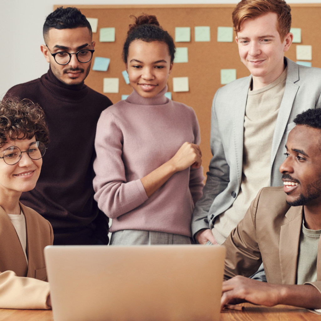 Diverse team of employees watching something fun on a laptop
