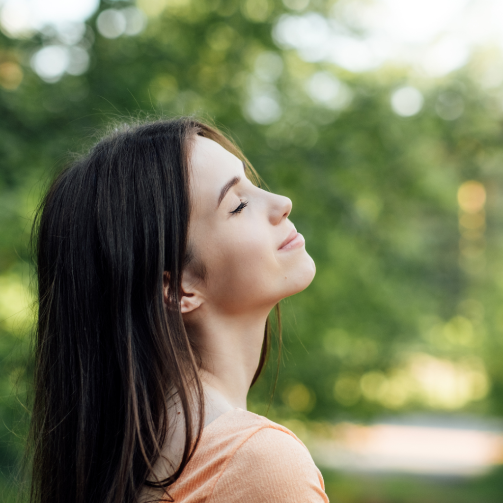 Ways To Unplug From Technology and Be Present. Unplugging from Technology and Living a More Mindful Life. Outdoor portrait of young woman enjoying nature
