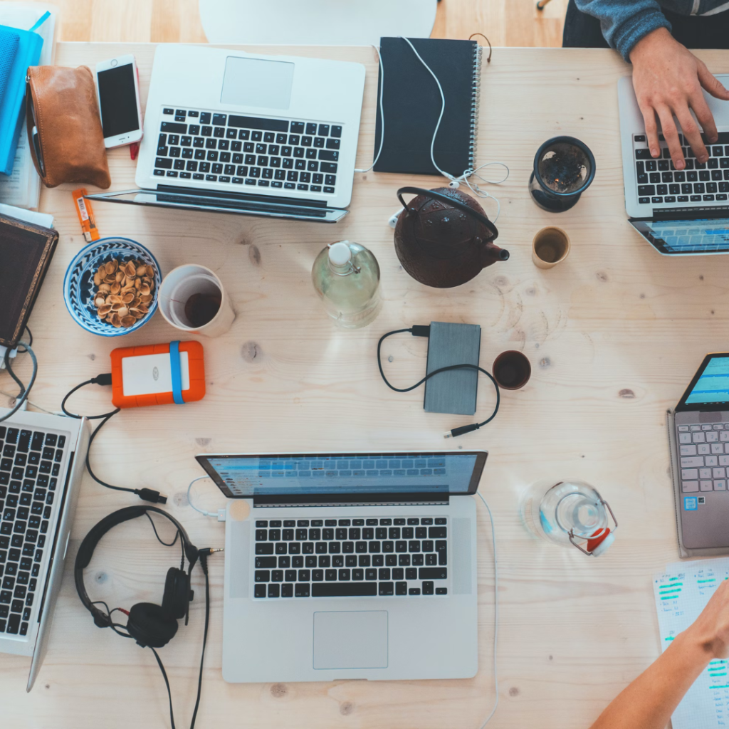 people sitting down near table with assorted laptop computers