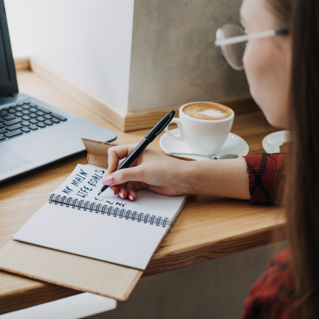 Main life goals, How to Set and Achieve Life Goals. Young woman girl writing in notebook life goals