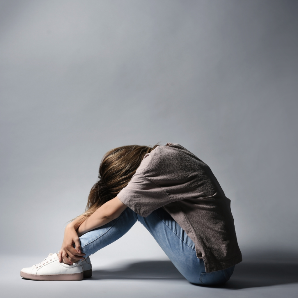 Lonely Depressed Woman Sitting on Grey Background