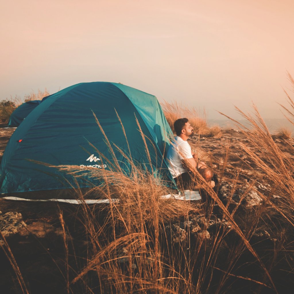 Photo of a Man Sitting Outside the Tent