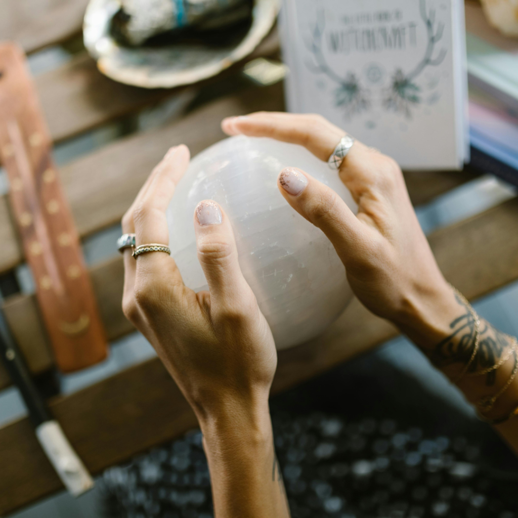 Hands Holding the Crystal Ball on the Wooden Table