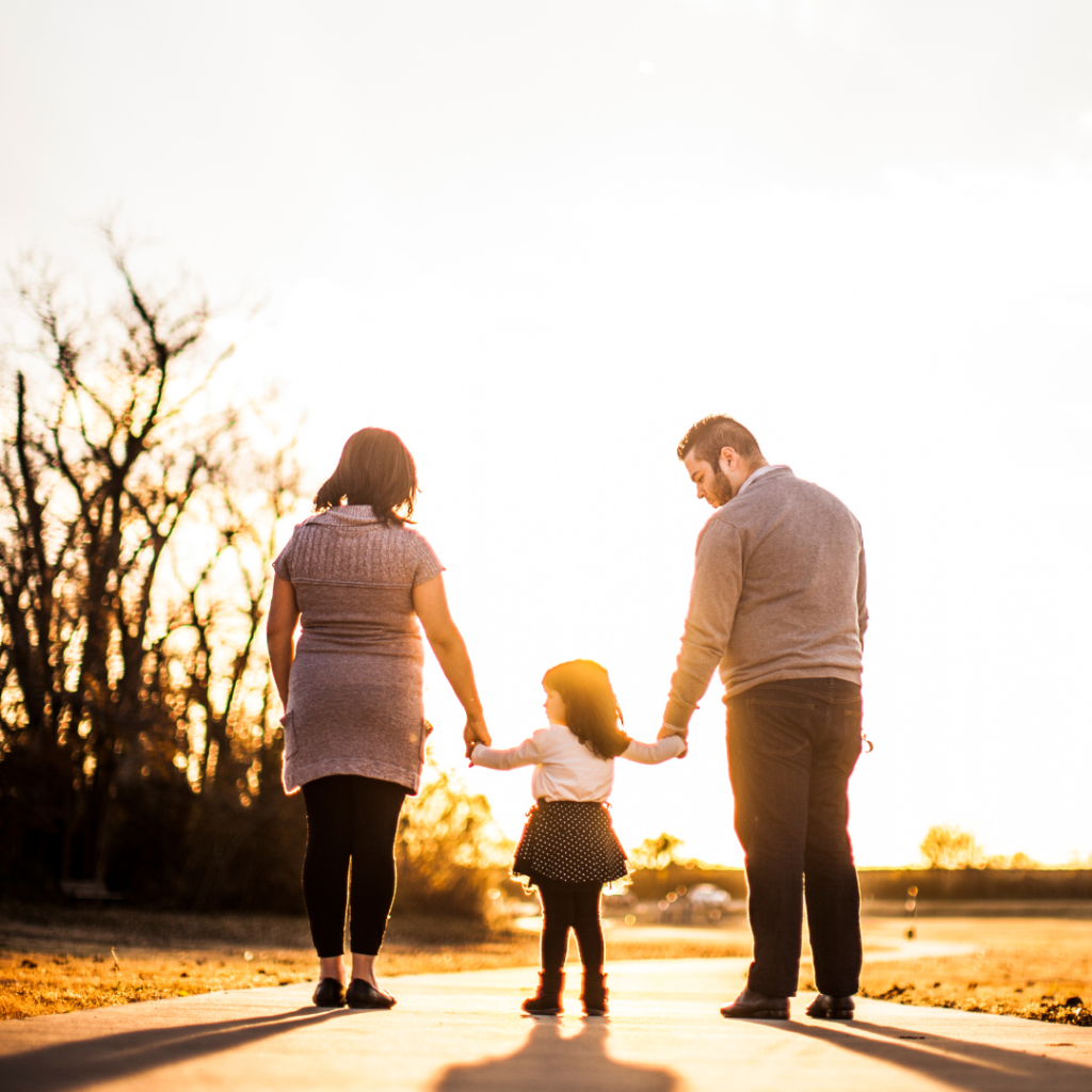 Photo of Family Standing Outdoors During Golden Hour